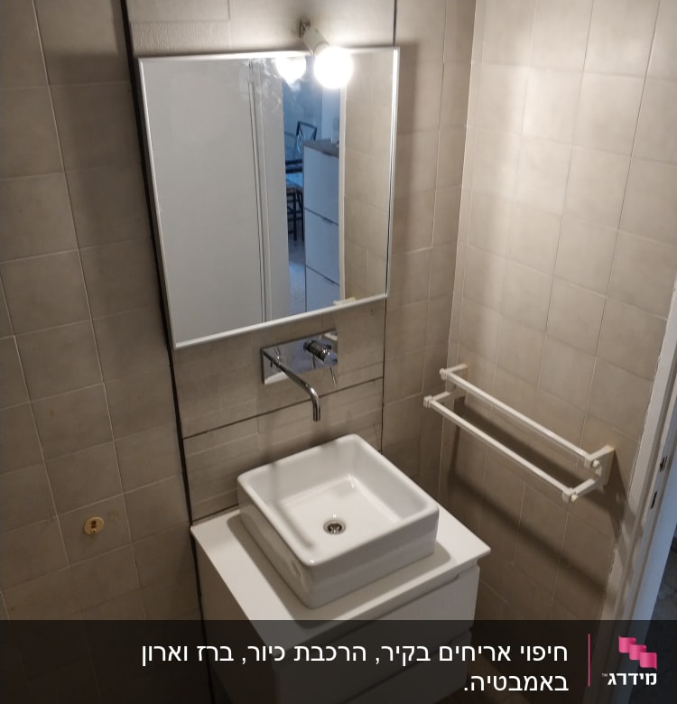 כיור חדש עם ברז מותקן על קיר אריחים
